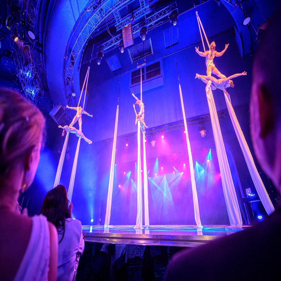 Aerial silk performers above an audience