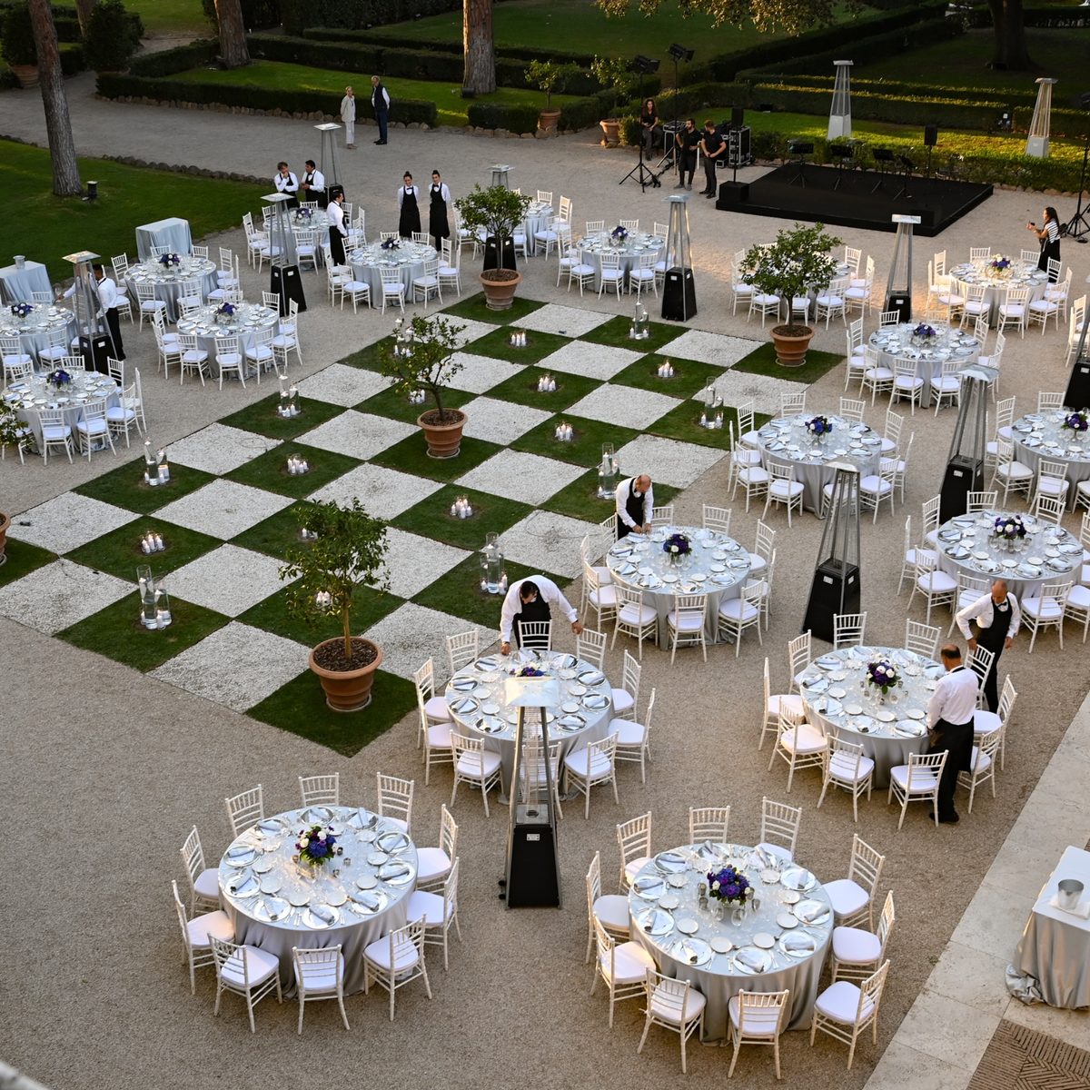 Dinner tables set in the gardens of an Italian villa